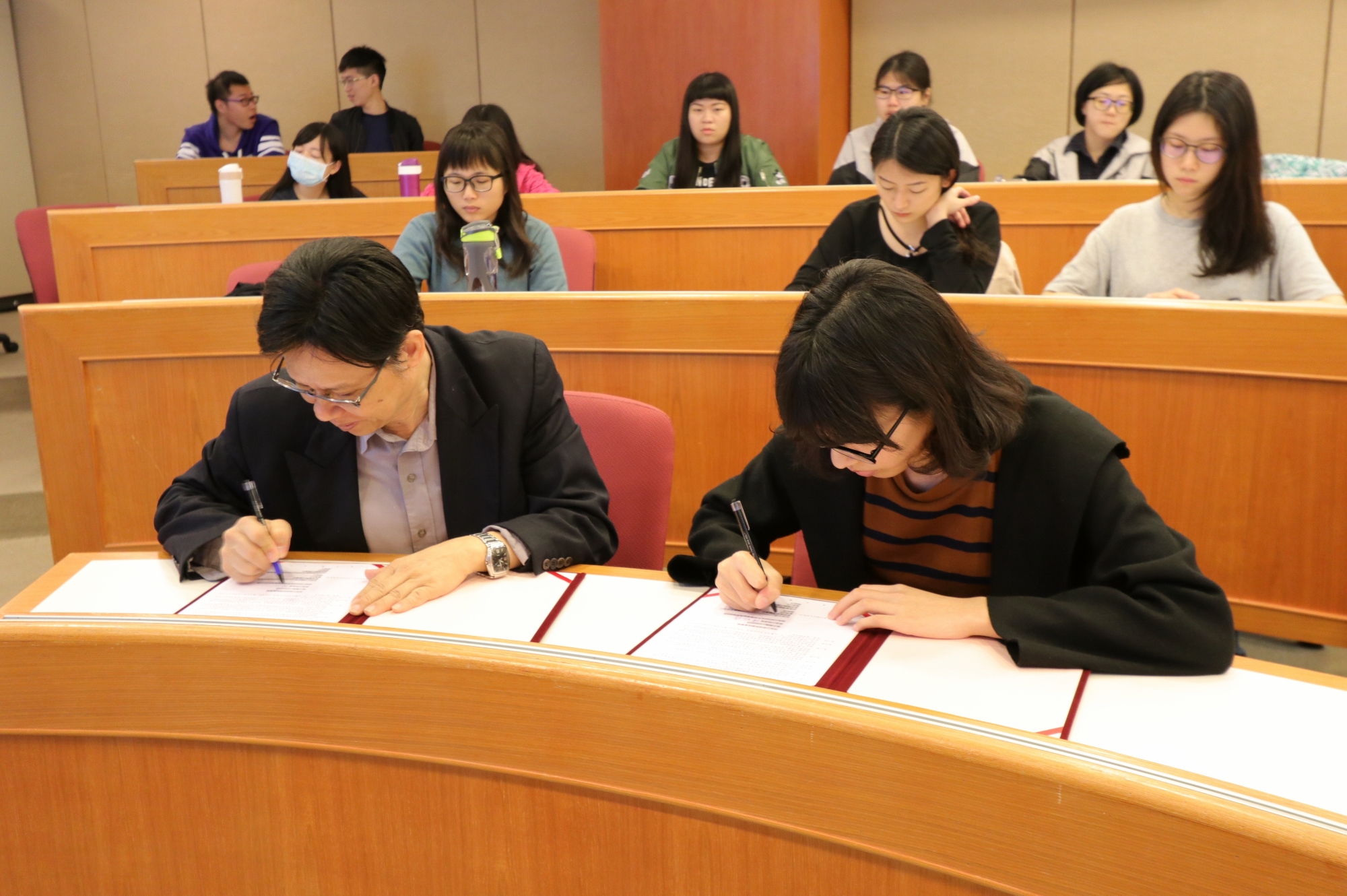 亞大附醫人事室陳昭偉主任(左)與護理系學生代表吳家綺簽訂獎助學金合約書。