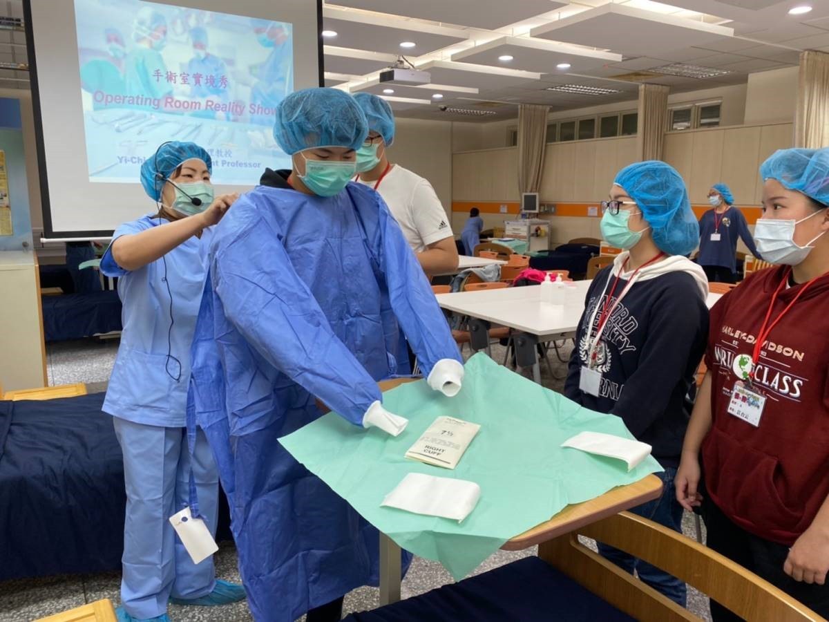護理系彭逸稘老師指導學員穿上外科無菌手術衣帽。