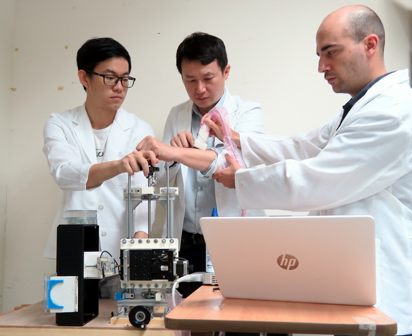 Vite Babak Hamun Akbari (from right), Professor Chi-Wen Lung, and Ph.D. student Wei-Cheng Shen develop and design a soft tissue ultrasonic measurement device