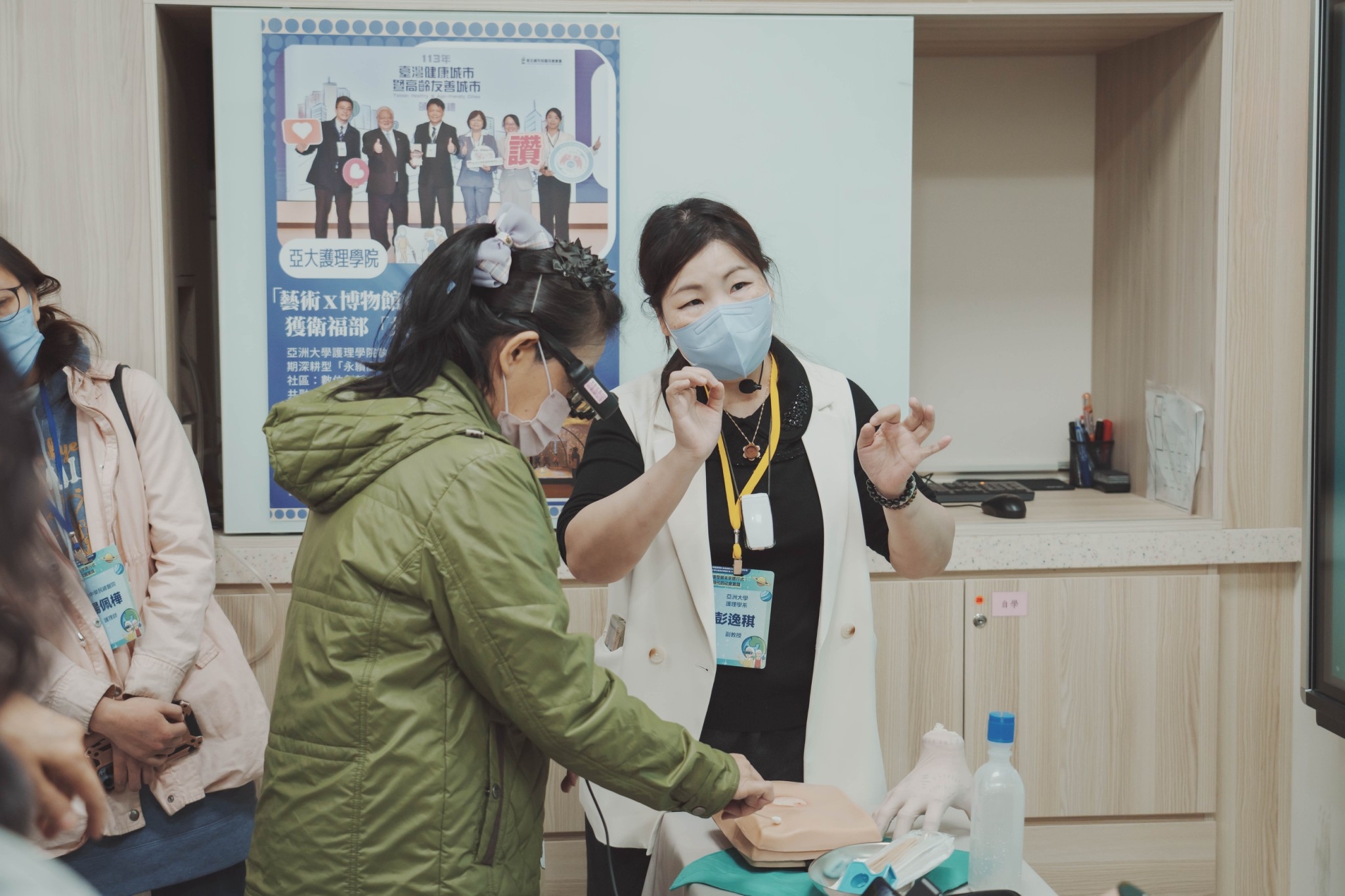 圖說: 護理學系彭逸稘老師於亞洲大學護理學院人才培育元宇宙基地展示「AI元宇宙助力長期照顧體驗」─AR擴增實境長照壓傷傷口照護實務教案。