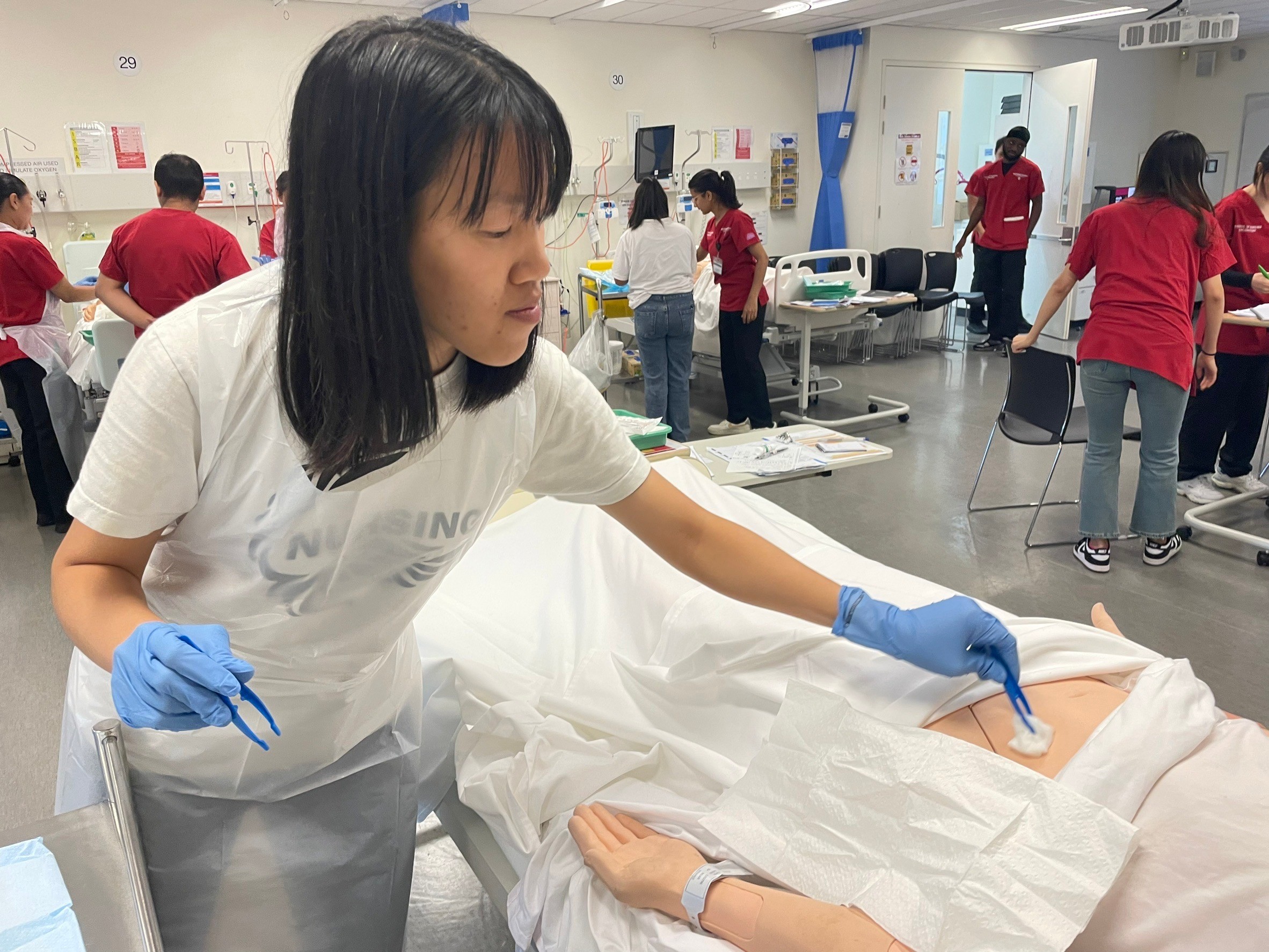 圖一、亞大護理學系甘智誼同學,在澳洲西雪梨大學Nursing LAB執行傷口換藥技術。