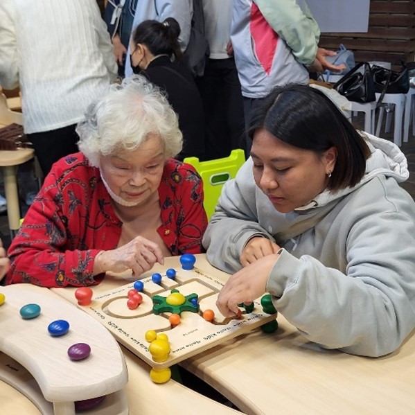 圖為亞大長照系同學和熟齡夥伴,一起玩益智遊戲。