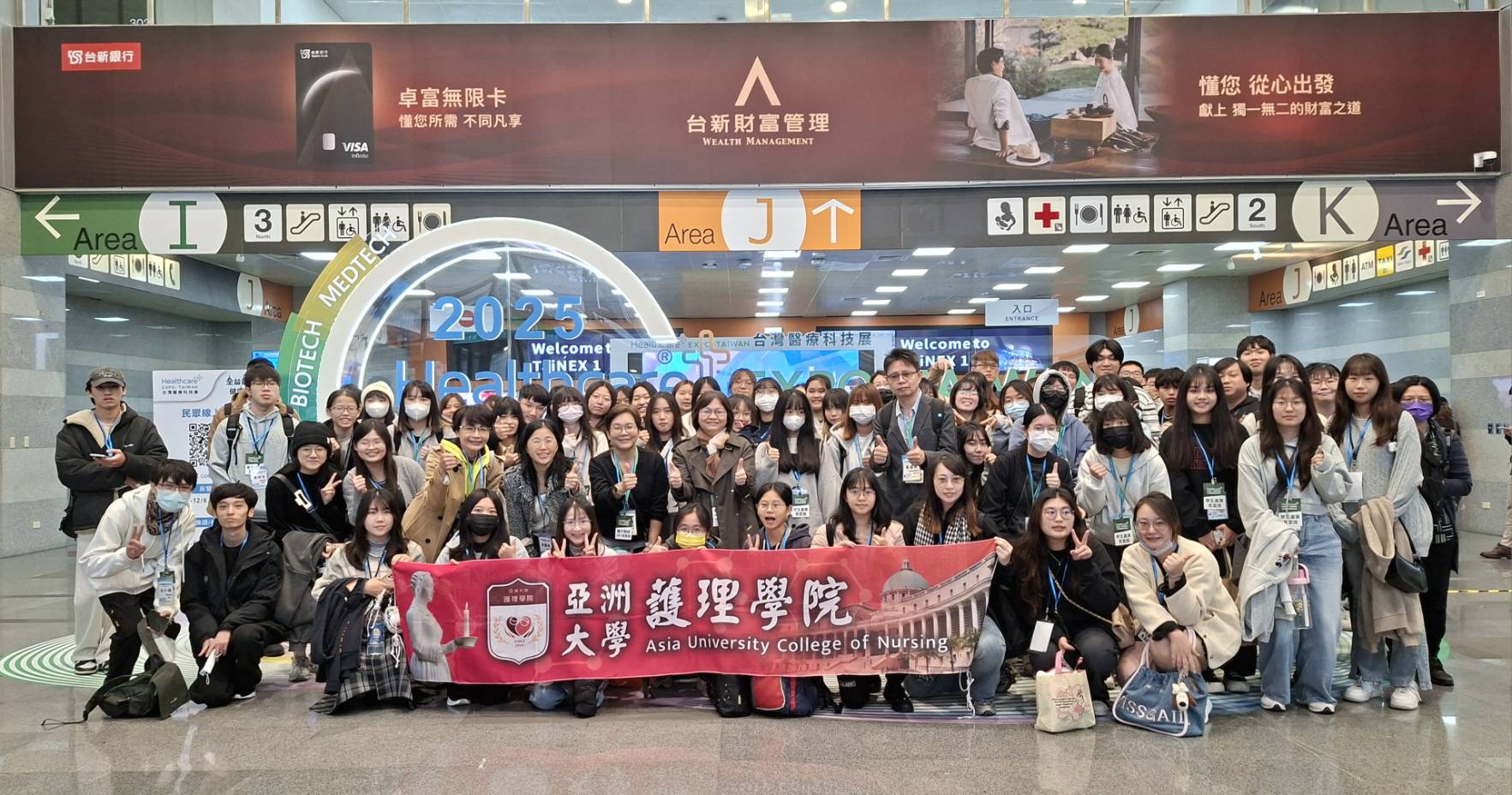 亞洲大學護理學院護理學系、長期照護學系、後護系80位師生於2025台灣醫療科技展場館入口處合影留念。