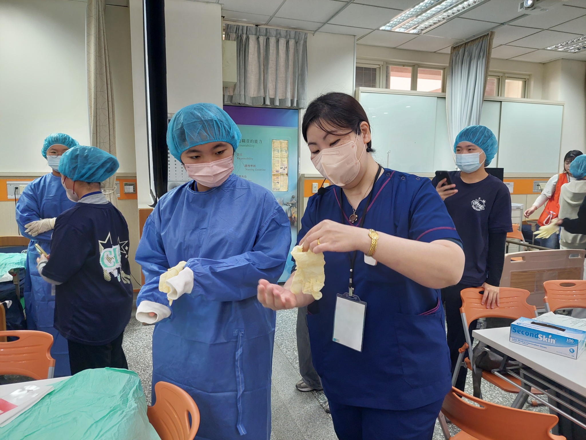 圖五、高中生參與手術實境秀，親身操作穿戴手術衣帽體驗。