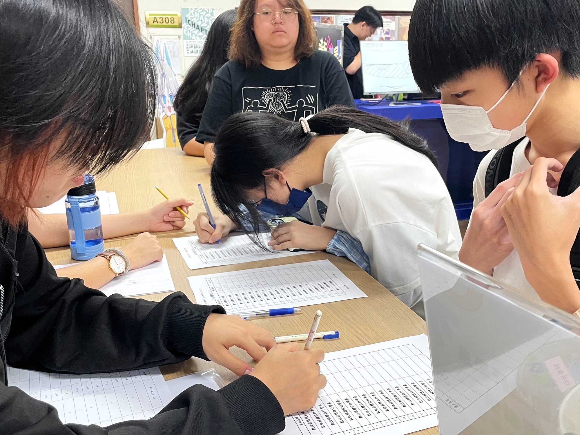 甄審說明會報到處，考生與志工認真填寫資料。